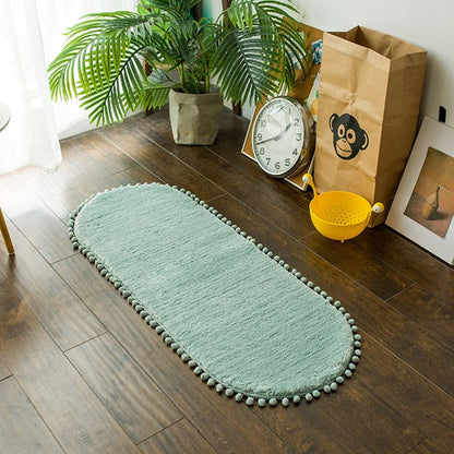 Ovaal vloerkleed met pompons en antislip