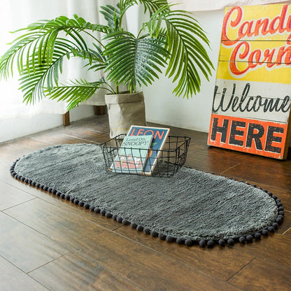 Ovaal vloerkleed met pompons en antislip